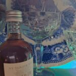 Et nærbillede af et smukt skåret krystalglas, der reflekterer lys i blå nuancer. Synlig traditionel blå og hvid platte i baggrunden.