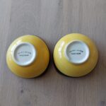 To vintage håndmalede tapasskåle med gule undersider og 'Del Rio Salado Hand Paint' mærkning på et træbord.