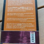 Adel forpligter af Dorothy L. Sayers og Jill Paton Walsh. Vist forfra med mystisk, tåget cover i lilla og brunlige nuancer.