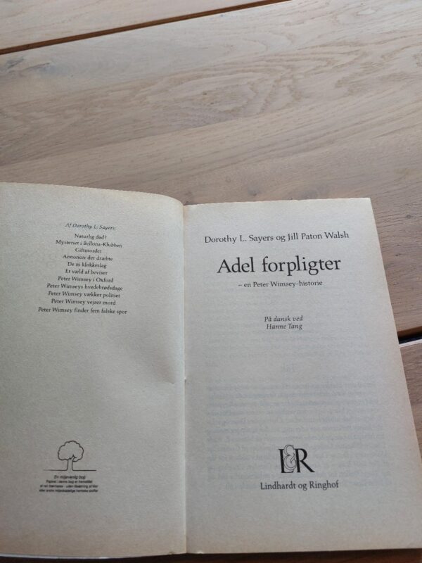 Bagsiden af bogen Adel forpligter med en beskrivelse af Lord Peter Wimsey og citater fra anmeldelser.