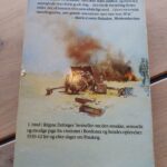 Forside af bogen Pigen med den blå cykel af Régine Deforges. Billede af en kvinde med cykel foran brændende hus.