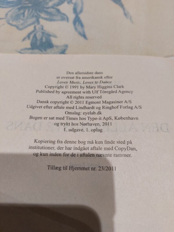 Et opslået side i bogen 'Den allersidste dans' af Mary Higgins Clark, med copyright- og udgiverinformation.