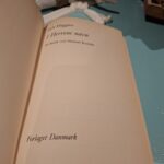 Indersiden af bogen 'I Herrens navn' af Jack Higgins, der viser titel, forfatter og forlag 'Forlaget Danmark'.