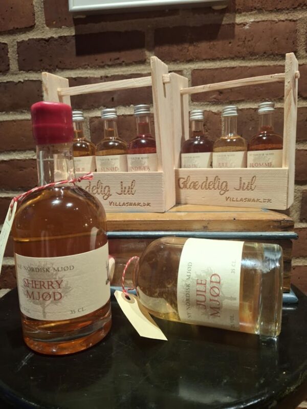 En trækasse med teksten 'Glædelig Jul Villasnak.dk', indeholdende små flasker mjød (Pære-Vanilje, Valnød, Hindbær). En stor flaske Sherry Mjød ses også.