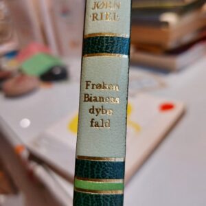 Et antikt messing-skrin og en souvenirflaske med Krudttårnet i Frederikshavn motiv, begge placeret på en træbaggrund.