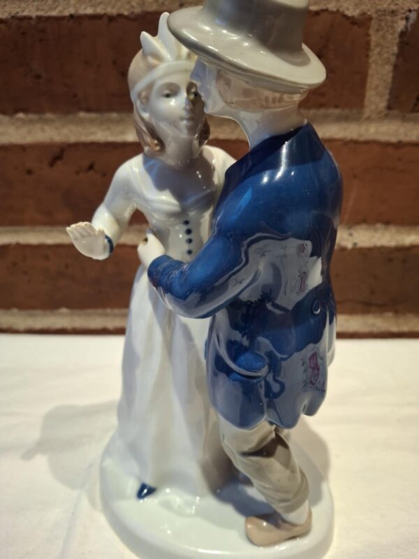 Højkvalitets porcelænsfigur af et dansende par. Manden i blå jakke, kvinden i hvid kjole, ansigterne tæt på hinanden.