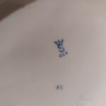 Billede af bunden af en porcelænsfigur, der viser mærket en krone med et 'S' og teksten 'GOR' nedenunder i blåt.