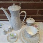 Et Rosenthal kaffesæt med kaffekande, sukkerskål, salt- og pebersæt samt en kaffekop og underkop. Alt i hvid porcelæn med gråt grafisk mønster.