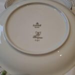 En enkelt Rosenthal Kongesaa tallerken med en elegant guldkant og et diskret gråt mønster, placeret på en hvid dug.