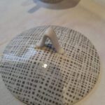 Nærbillede af låget på en Rosenthal sukkerskål/bonbonniere, der viser det grå grafiske mønster og et lille håndtag på toppen.