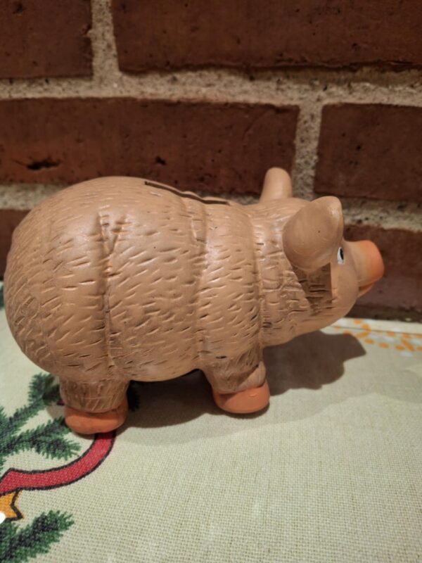 En terracotta sparegris set fra siden, der viser dens karakteristiske form og strukturerede overflade. På juledug.