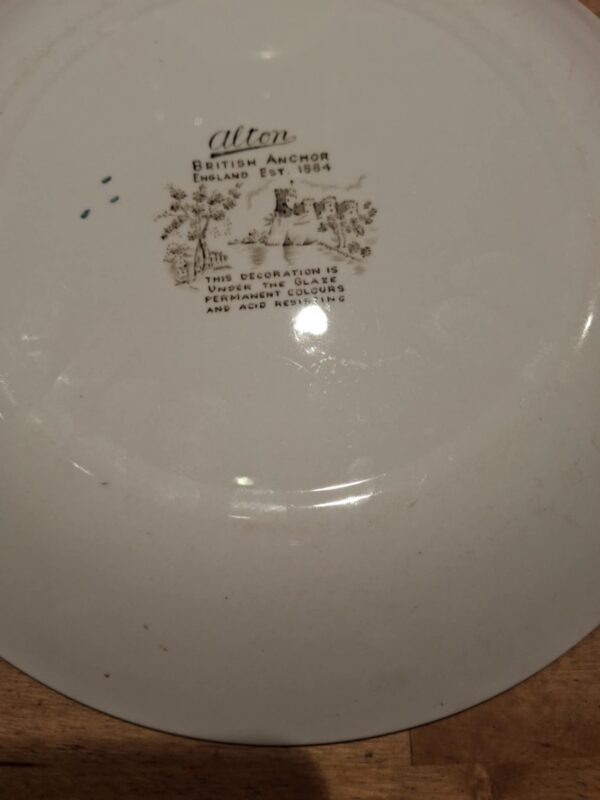 Bagsiden af en hvid tallerken med teksten 'Alton British Anchor England Est. 1914', omgivet af et lille landskabsmotiv.