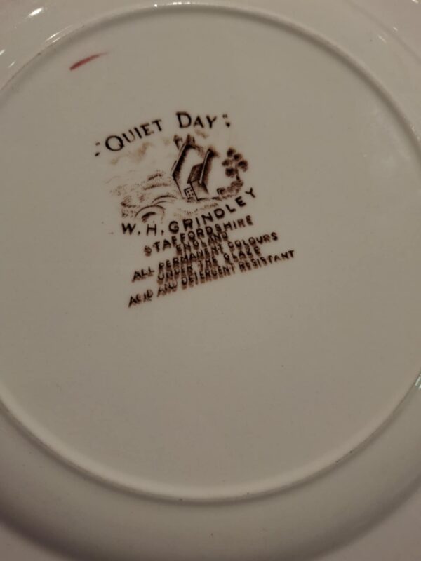 Bagsiden af en hvid 'Quiet Day' tallerken i fajance, der viser producentens stempel 'W.H. Grindley & Co Staffordshire England'.