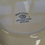 Nærbillede af bagsiden af et 'Victorian' fad fra Johnson Bros., hvor et blåt stempel med 'Victorian', 'JOHNSON BROS', 'MADE IN ENGLAND' og en krone er tydeligt synligt.
