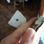 Hånd der holder stik til natlampe på mørk baggrund