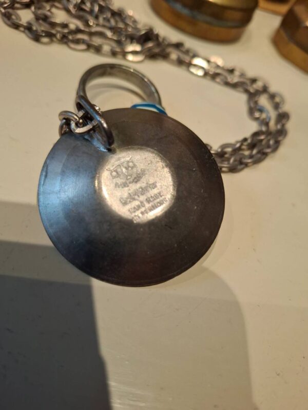 Indgravering på bagsiden af tinvedhæng: Hand Made in Denmark