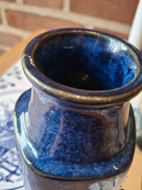 Top af blå keramikvase med lille chip