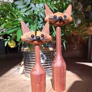 To vintage trækattefigurer i varm træfarve med detaljerede ansigter og spidse ører