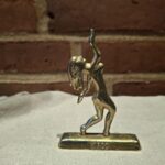 Messingfigur af jomfru på beige klæde