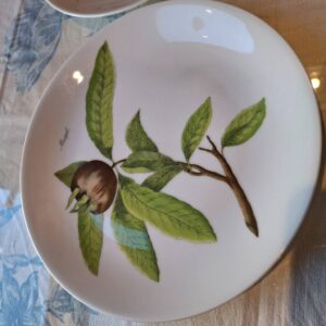 Porcelænstallerken med frugtillustration og grønne blade