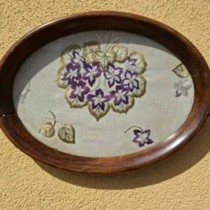 Oval bakke med træramme og broderi af lilla blomster