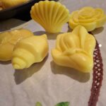 Gule håndsæber formet som muslingeskaller og blomster