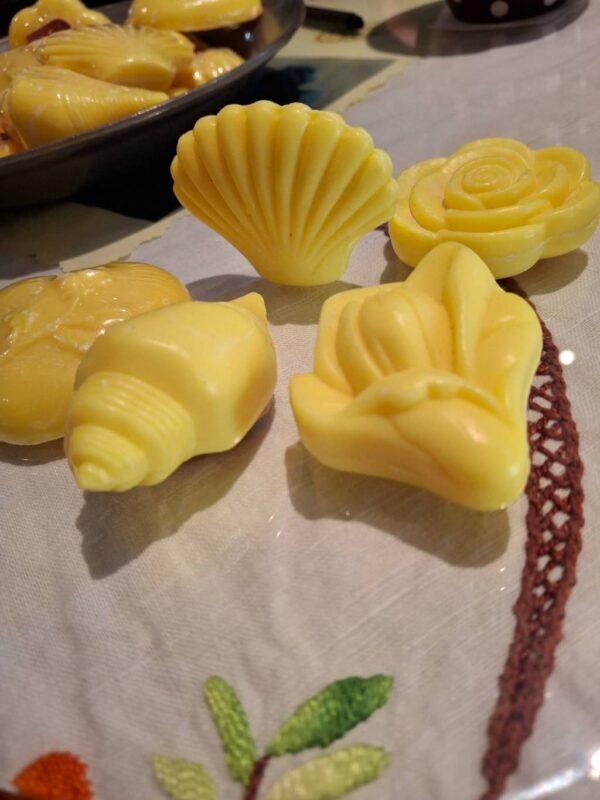 Gule håndsæber formet som muslingeskaller og blomster