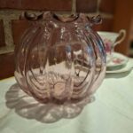 Rosa glasvase med bølgende kant og lodrette riller