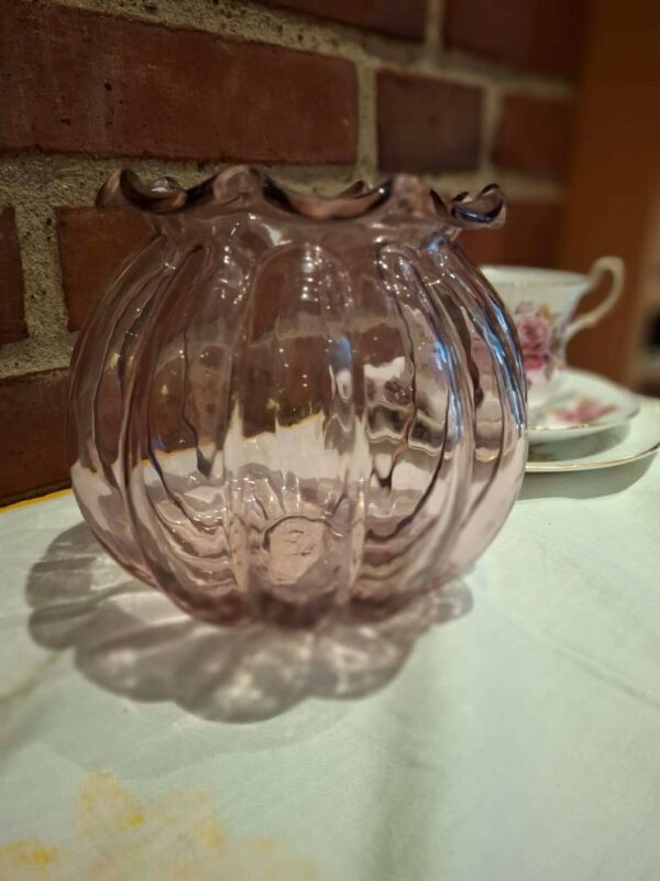 Rosa glasvase med bølgende kant og lodrette riller