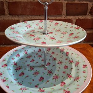 To-etagers kagefad med lysegrøn baggrund og rosemønster