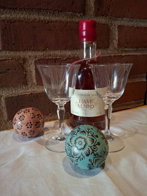 To graverede glas foran flaske med rødt segl