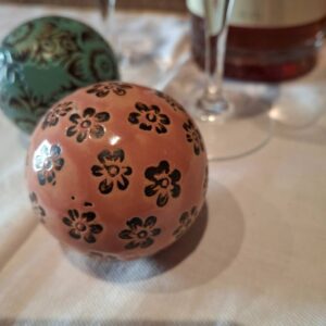 Rosa kugle med sort blomstermønster på en dug