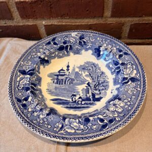 Blå porcelænsskål med landskabsmotiv og blomsterbort