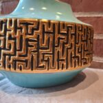 Nærbillede af blå vase med gyldent reliefmønster