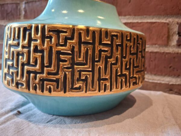 Nærbillede af blå vase med gyldent reliefmønster