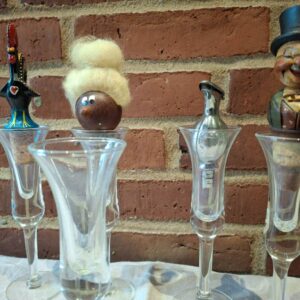 Fem tulipanformede glas med dekorative propper i række