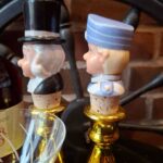 To guldfarvede lysestager med figurer fotograferet fra siden
