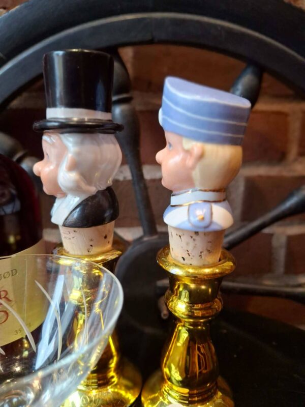 To guldfarvede lysestager med figurer fotograferet fra siden