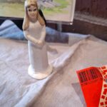 Hvidklædt plastikfigur af pige