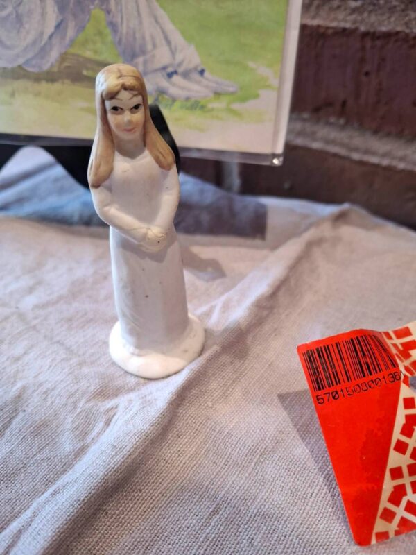 Hvidklædt plastikfigur af pige