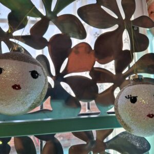 To glitrende kugler med ansigter foran metalbaggrund