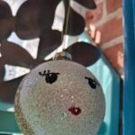 Kugle med glimmer, røde læber og sorte øjenvipper