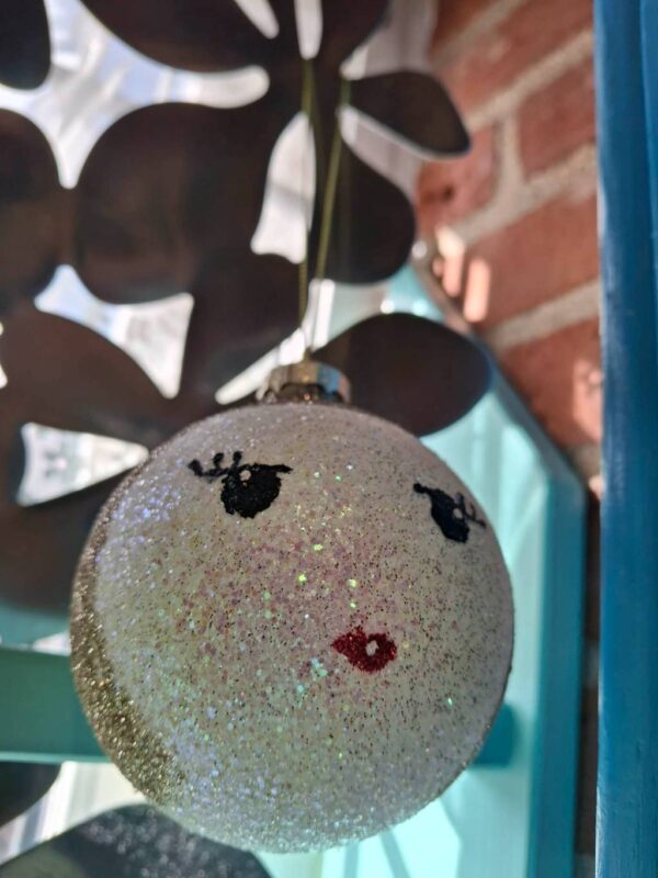 Kugle med glimmer, røde læber og sorte øjenvipper