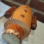 Træfigur liggende med fokus på knapper og bunddetaljer