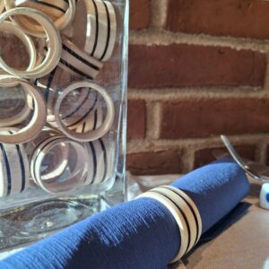 Lys træservietring med sorte striber i glasbeholder