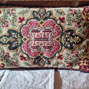 Pude med håndbroderet mønster i røde og gyldne farver