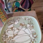 Kvinde med blomster i guld på Bjørn Wiinblad tallerken