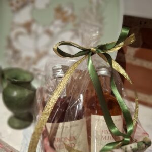 Gavekurv med to små flasker mjød, pakket i cellofan med grønt og guld bånd. Flaskerne er Aronia Mjød og Hyben Mjød.