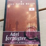 Forsiden af Adel forpligter af Dorothy L. Sayers og Jill Paton Walsh med gadelamper og et forstørrelsesglas.