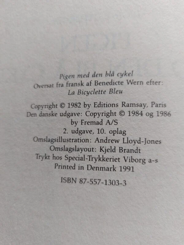 Bagsiden af bogen Pigen med den blå cykel med en anmeldelse og beskrivelse af bogens historie.